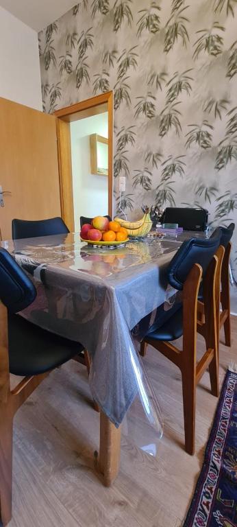 a dining room table with a bowl of fruit on it at 3 Schlafzimmer &Wohnküche in Oberhausen