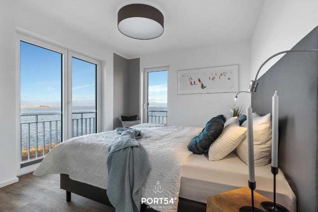 a bedroom with a bed with a view of the ocean at Lütthoorn in Olpenitz