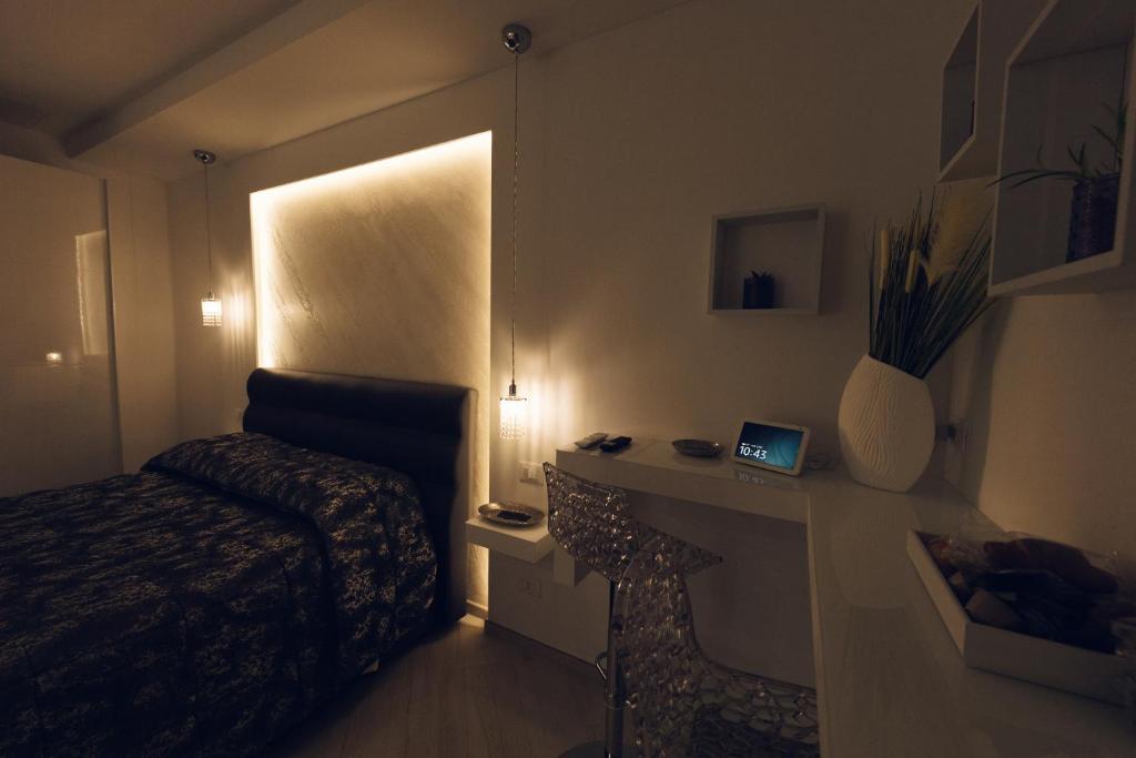 Schlafzimmer mit einem Bett und einem Schreibtisch mit einem Laptop in der Unterkunft Gandrè Room in Mesagne