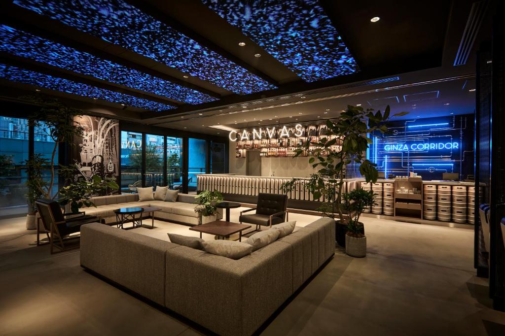 a lobby with a couch and tables and a bar at The Royal Park Canvas Ginza Corridor in Tokyo