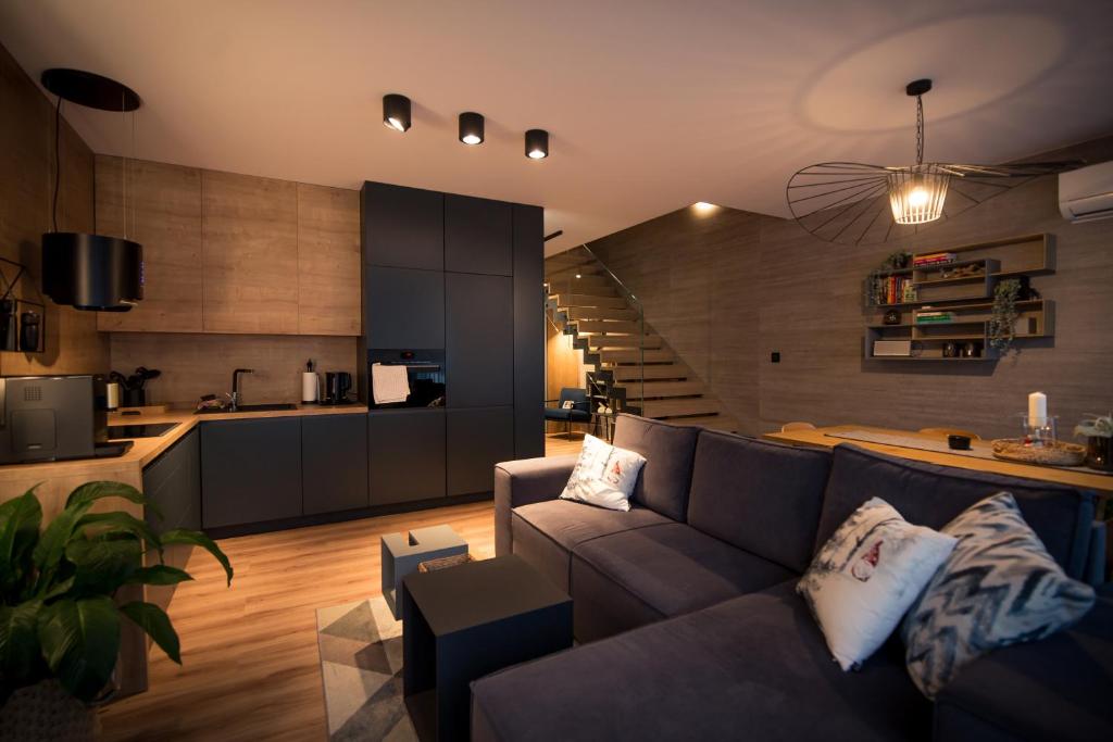 salon z kanapą i kuchnią w obiekcie ApartView Plażowa Residence Szczyrk by Rent like home w Szczyrku