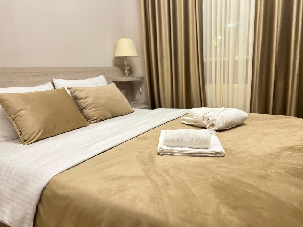 a hotel room with a large bed with towels on it at Family Hotel Triston in Tbilisi City