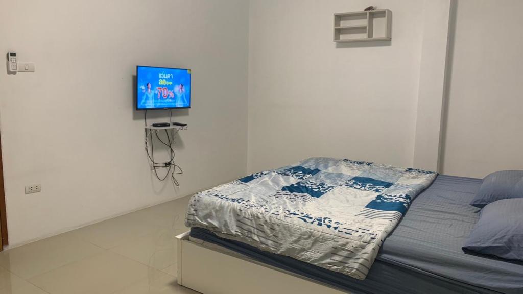 sypialnia z łóżkiem i telewizorem z płaskim ekranem w obiekcie Min&Me House Pattaya w mieście Nong Prue
