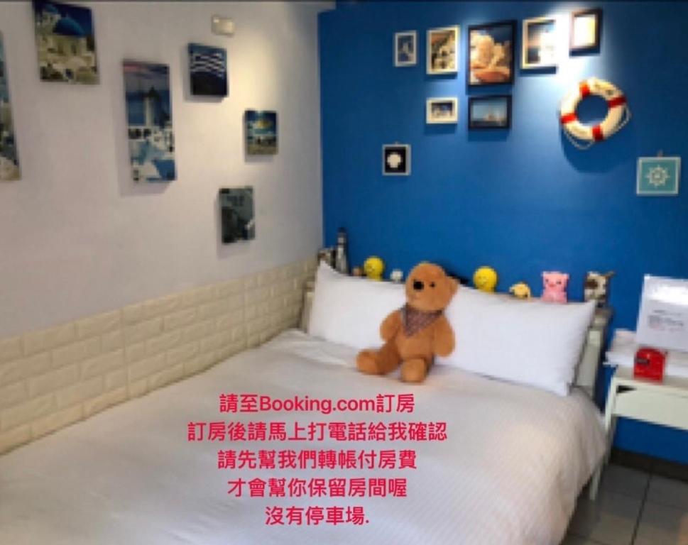 a teddy bear sitting on top of a bed at Jacky's House Ximen in Taipei