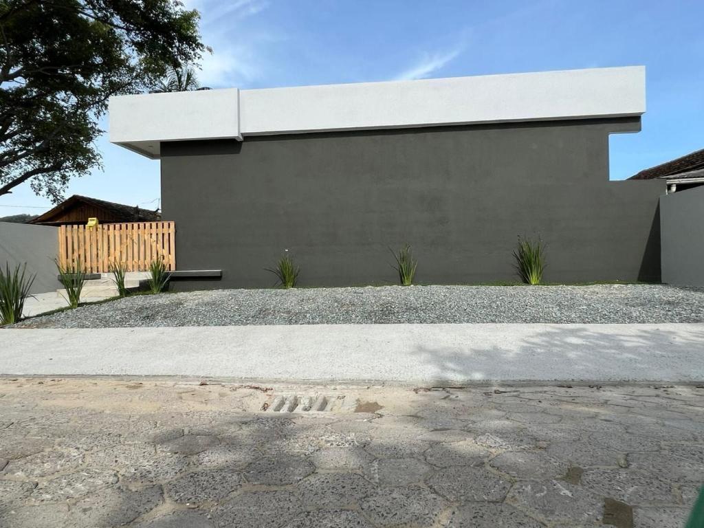 una casa gris con un banco delante en Villa 61 | Hospedagem, Praia de Armação, Beto Carrero - SC, en Penha