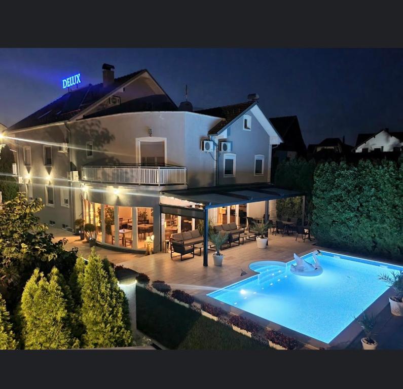 a large house with a swimming pool in front of it at Vila DeLux in Negotin