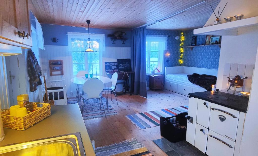 a kitchen and living room with a table and a bed at Gårdshus in Lit