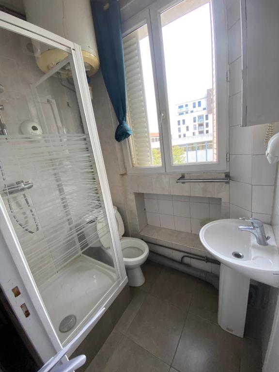 a bathroom with a shower and a toilet and a sink at RENT APPART - Colombes in Colombes
