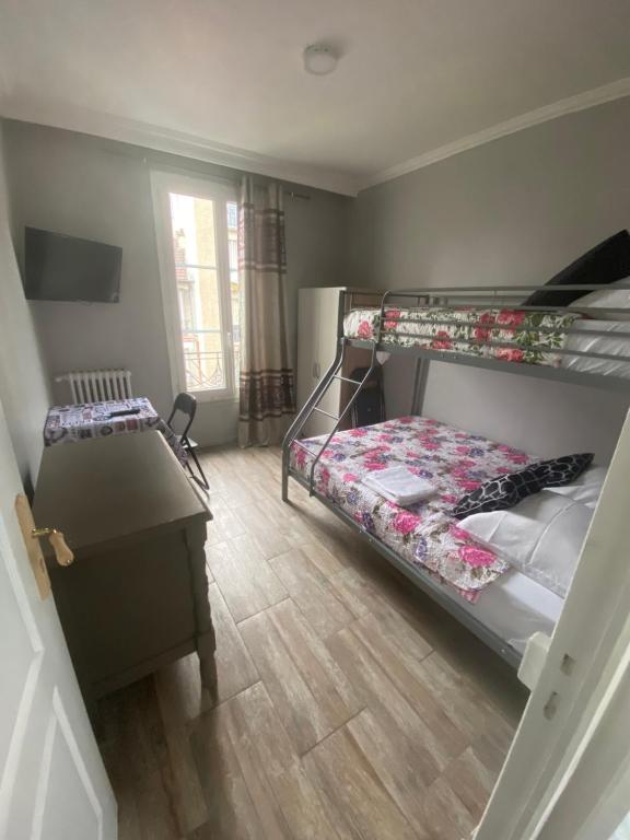 a bedroom with two bunk beds and a desk at RENT APPART - Colombes in Colombes