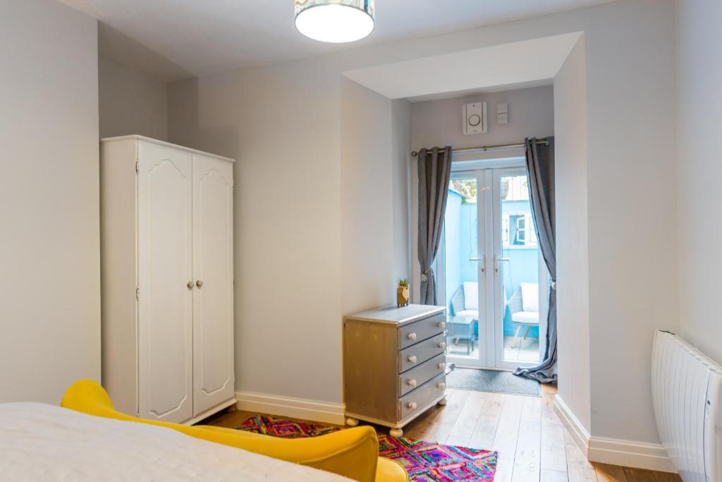 a bedroom with a bed and a dresser and a window at No 31 Promenade APARTMENT by the sea in Aberystwyth