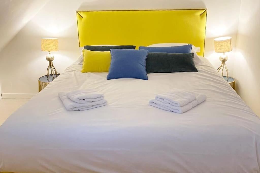 a large white bed with two towels on it at Appartement Miramar - Plage 50m - Rue gratuite in Saint Malo