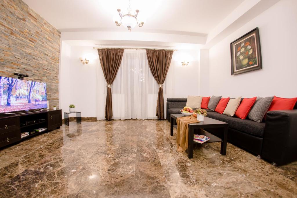Una sala de estar con un sofá y un televisor. en Luxury Down Town, en Bucarest