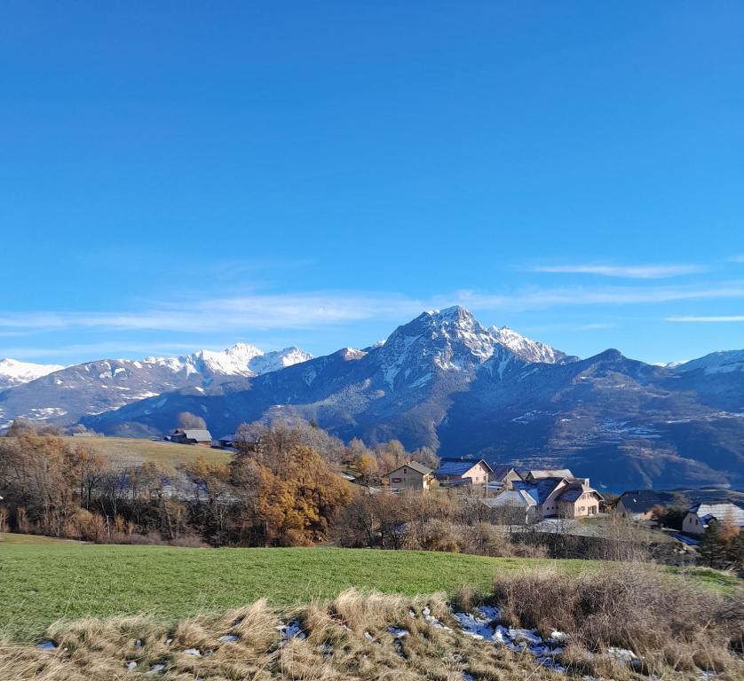 a house in a field with mountains in the background at Le Piolit in Prunières