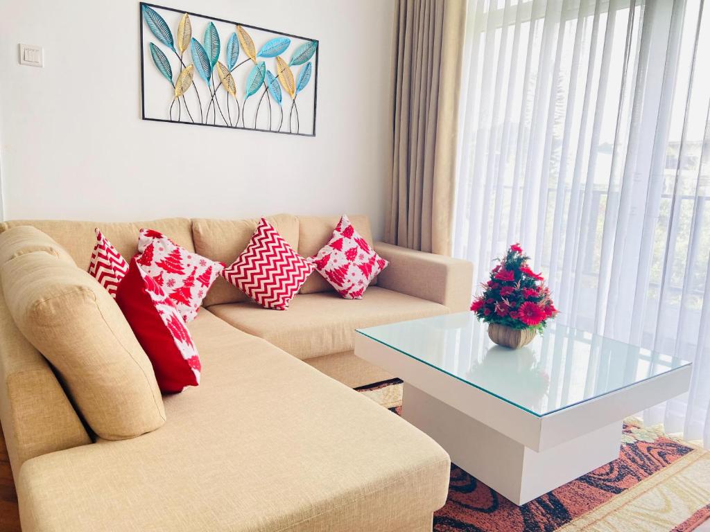 un soggiorno con divano e tavolo in vetro di Grand Winterberry - Lake View Luxury Residence a Nuwara Eliya