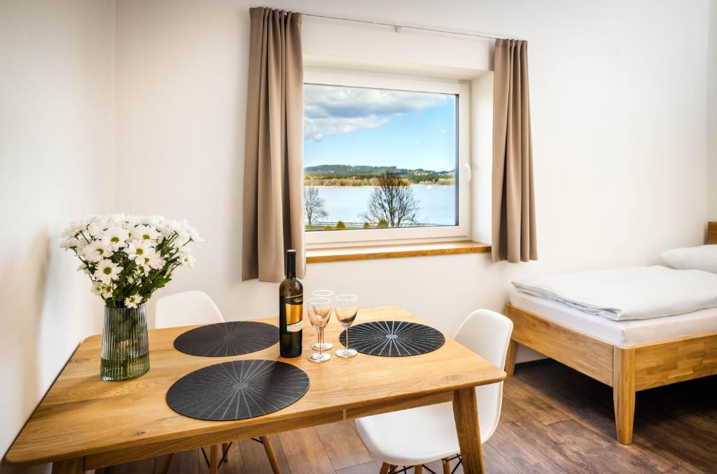a dining room with a table and a window at Apartmány Panelka Costa Plana Lipno in Černá v Pošumaví