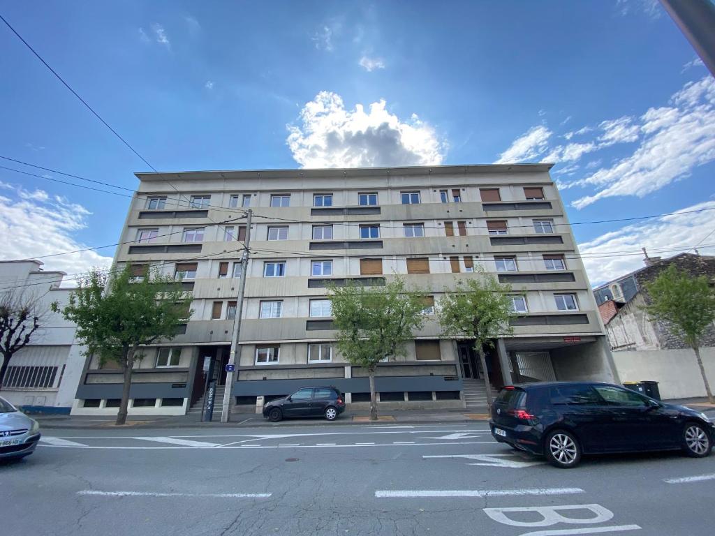 a large building with cars parked in a parking lot at COSY in Clermont-Ferrand