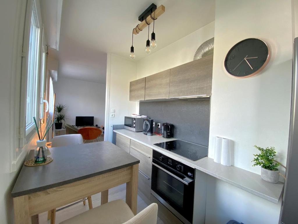 a kitchen with a counter and a clock on the wall at COSY in Clermont-Ferrand