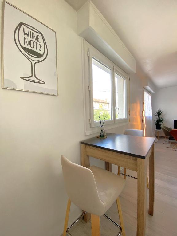 a dining room with a wooden table and a white chair at COSY in Clermont-Ferrand