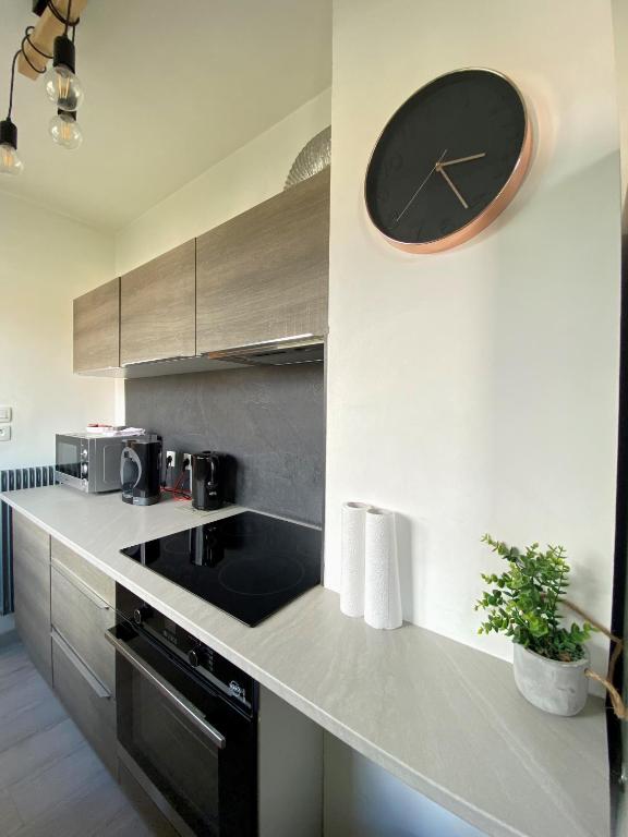 a kitchen with a clock on the wall at COSY in Clermont-Ferrand