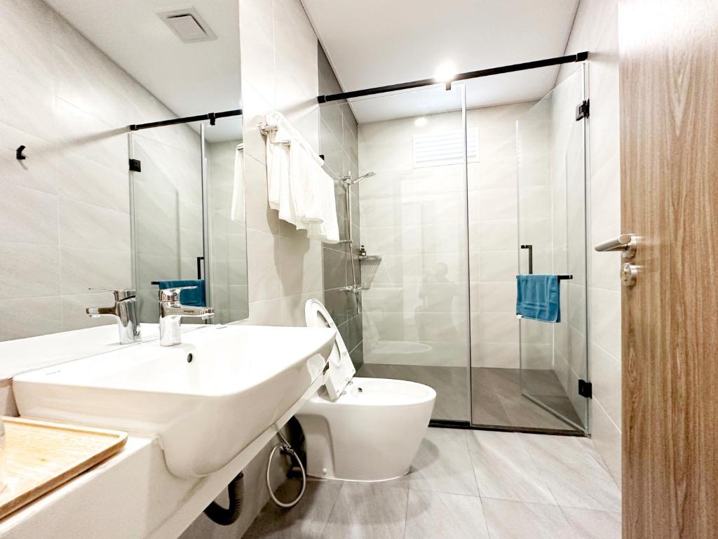 Un baño con lavabo, inodoro y ducha. en HERA HOSTEL, en Chau Doc