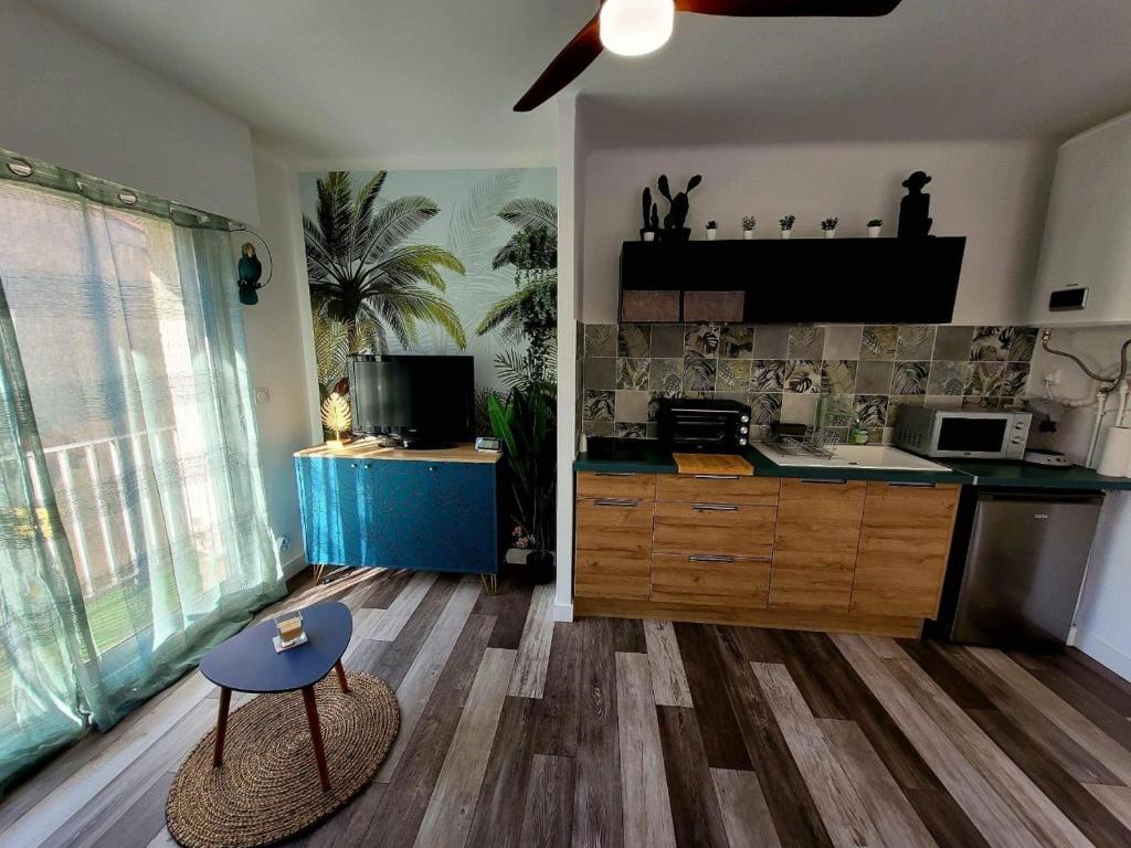 uma cozinha com uma mesa no meio de uma sala em AS22776 - Charmant studio au cœur du centre ville à 2 pas de la plage em Le Grau-du-Roi