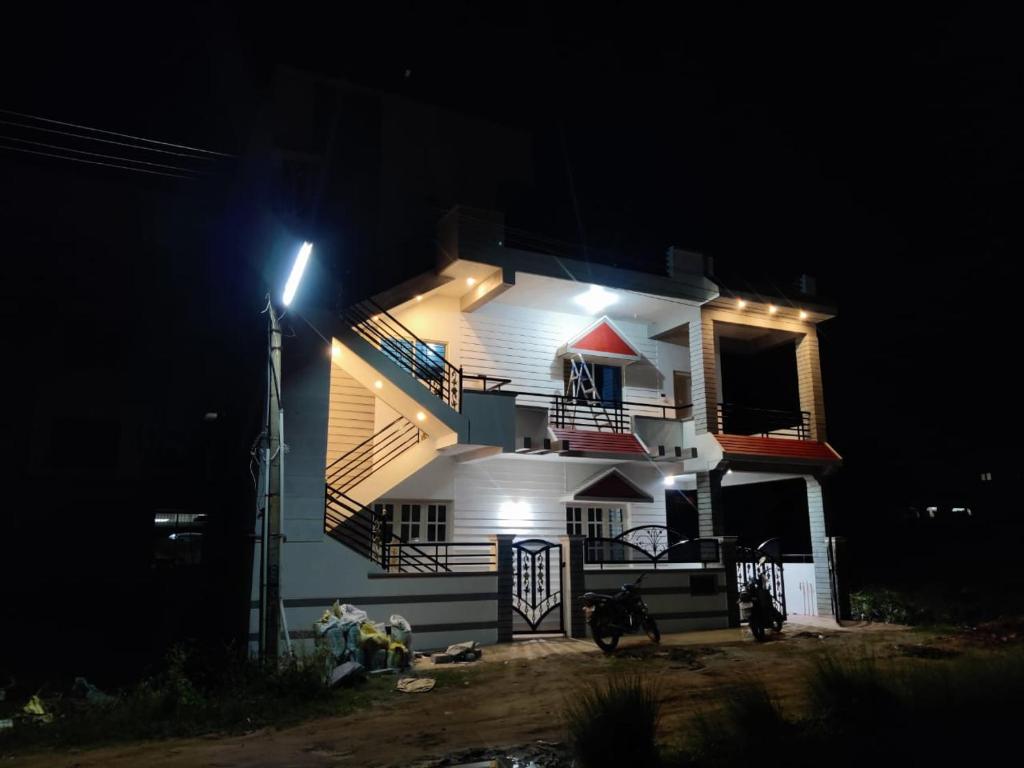 una casa blanca con una luz de la calle en la oscuridad en Happy holiday Inn en Chikmagalūr