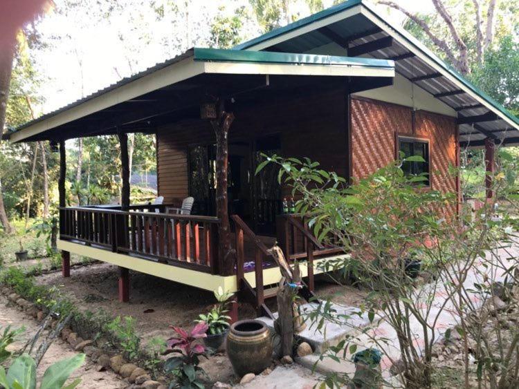 una pequeña casa con una gran terraza en un bosque en Loma Sea Views, en Ko Jum