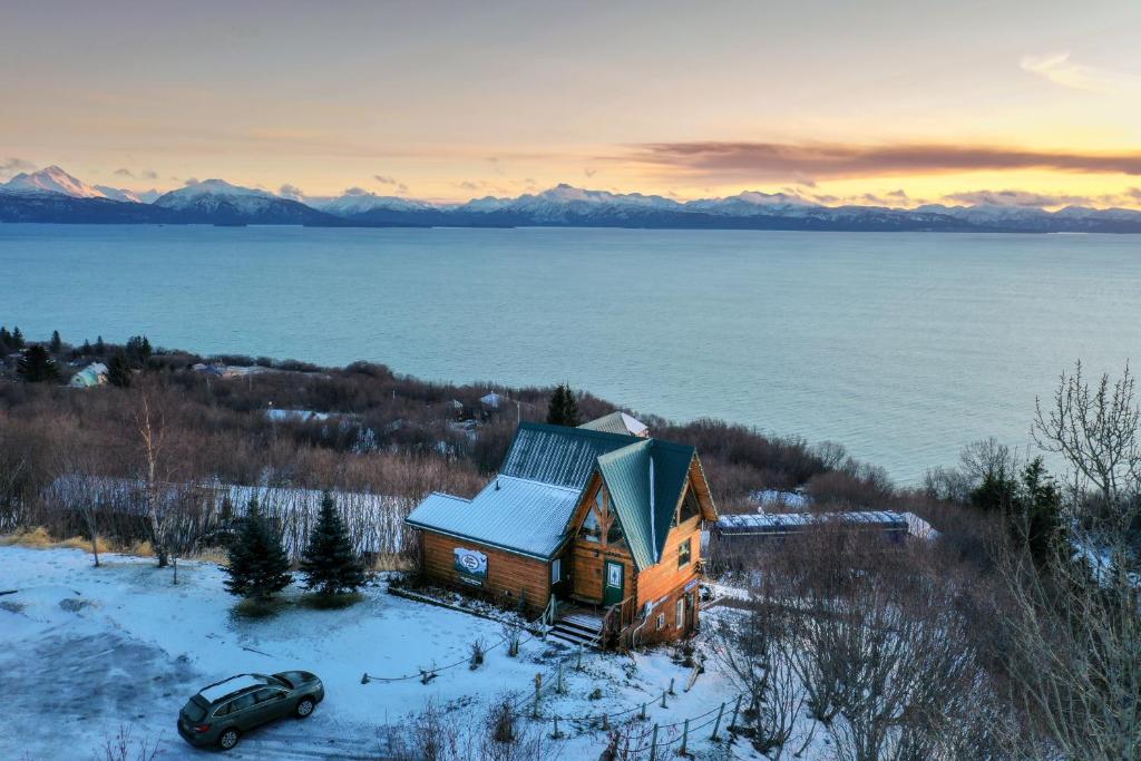 a house in the snow with a car in front of it at Alaska Adventure Cabins in Homer