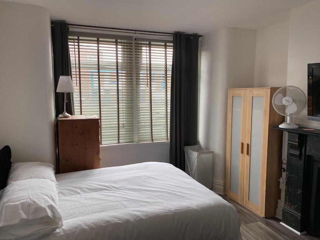 een slaapkamer met een wit bed en een raam bij Quality Accommodation in Leeds