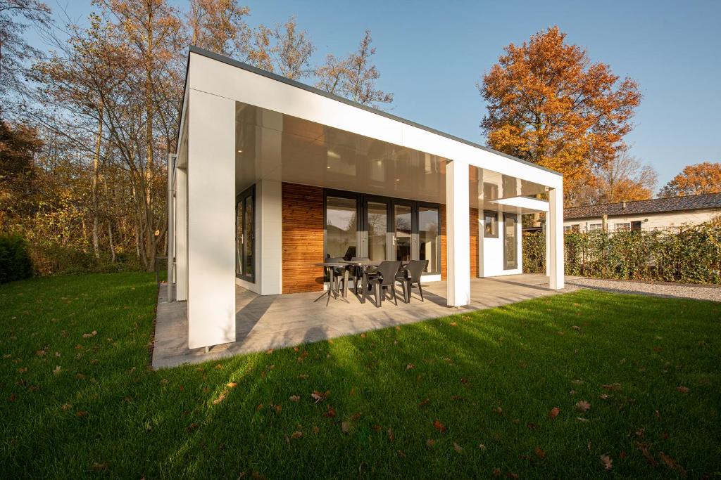 ein modernes Haus mit einer Terrasse und Gras in der Unterkunft 95, gelegen aan het natuurmonument de Kampina in Oisterwijk