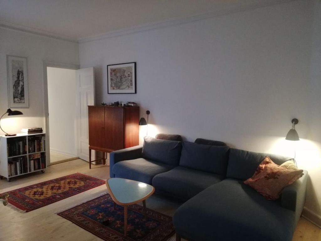 コペンハーゲンにあるApartmentInCopenhagen Apartment 397のリビングルーム(青いソファ、テーブル付)