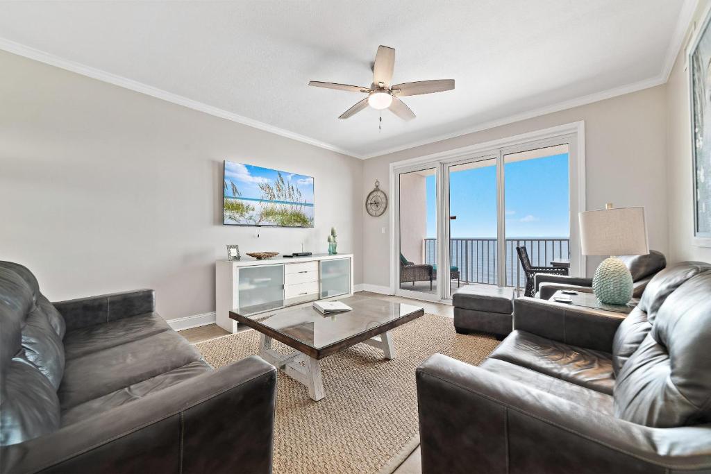 a living room with leather furniture and a view of the ocean at Windemere 1003 in Perdido Key