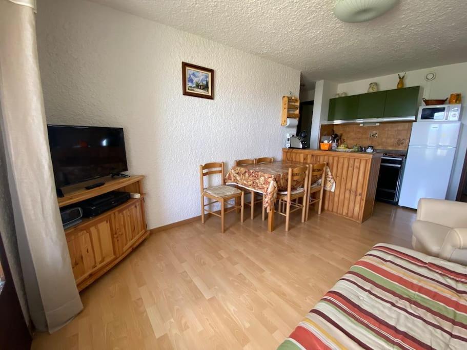 a living room with a dining table and a kitchen at Laye Station - Appartement pieds des pistes in Laye