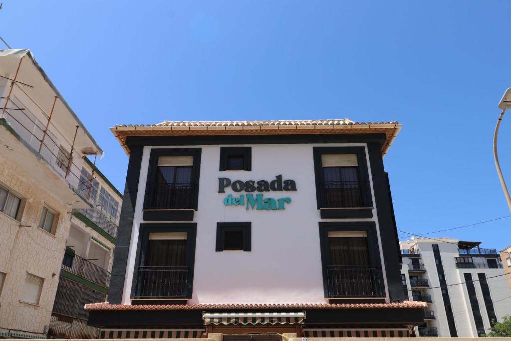 a building with a sign on the side of it at 203 I Posada del Mar I Encantador hostel en la playa de Gandia in Los Mártires