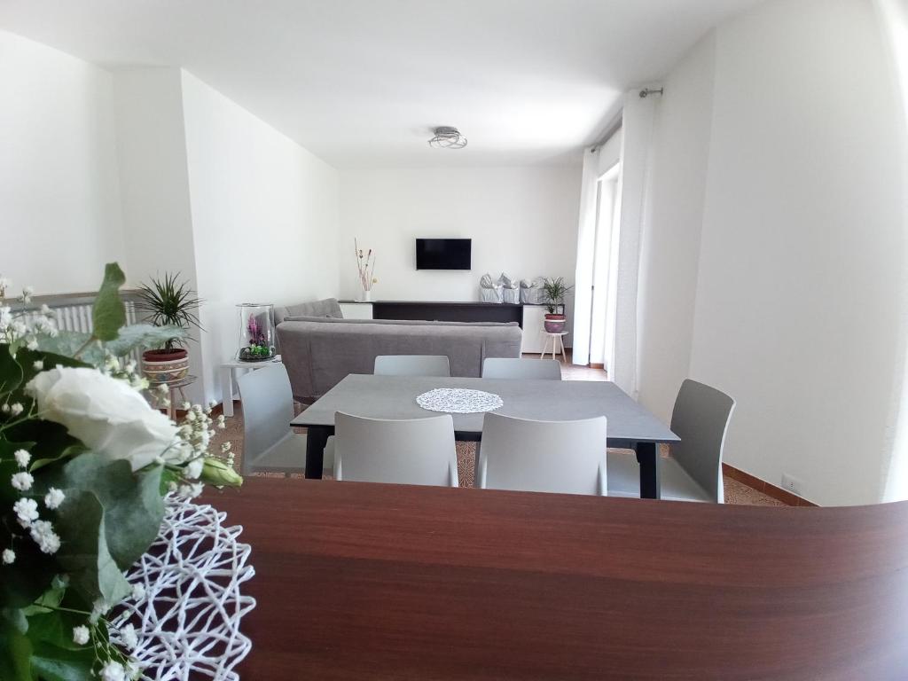 Canzo的住宿－Appartamento L'Airone Cenerino，一间带桌子和白色椅子的用餐室