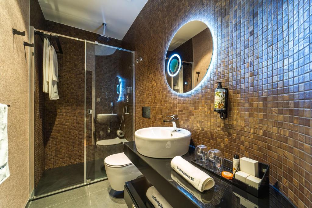 a bathroom with a sink and a toilet and a mirror at Lux Housing Século XXI in Braga