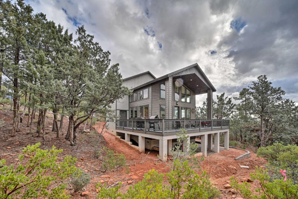 a large house on a hill with trees at Pine Cabin with Hot Tub and Mountain Views in Pine