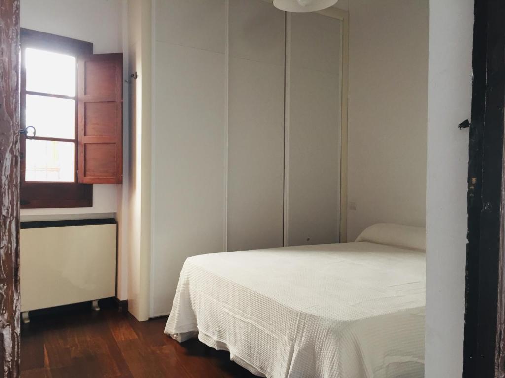 a bedroom with a white bed and a window at El Ventanillo in Toledo