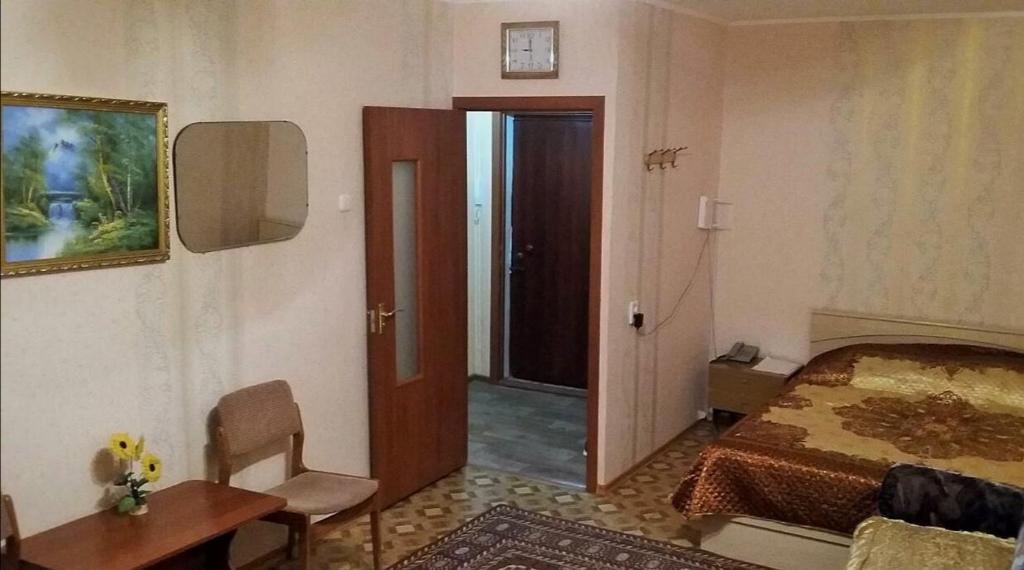 a room with a bedroom with a bed and a door at Однокомнатная Встреча in Astana