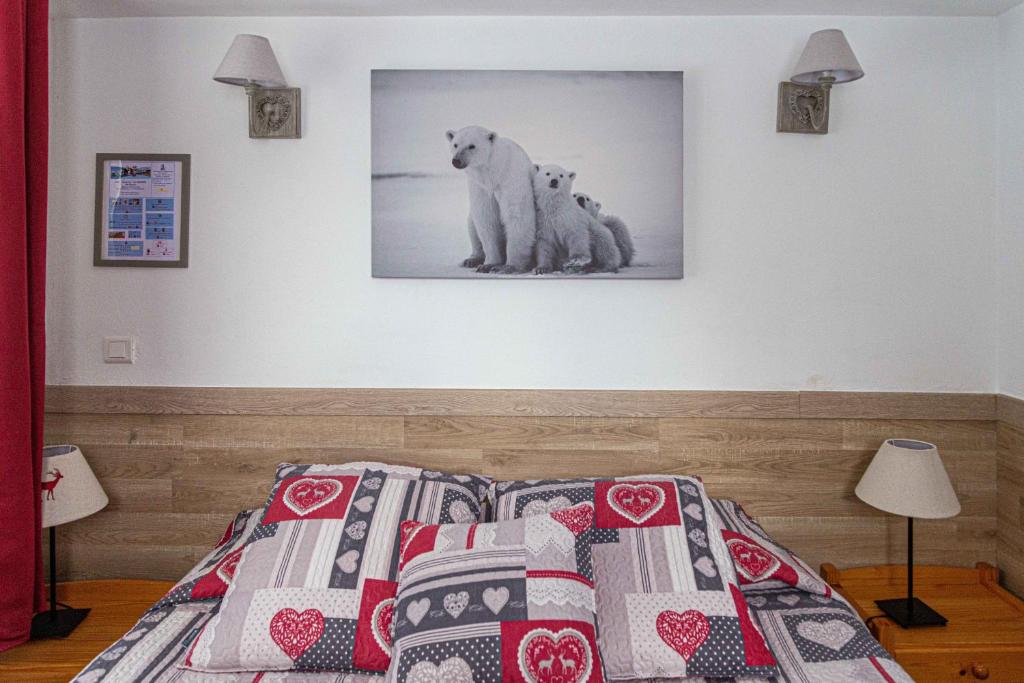 a bedroom with a bed with two polar bears on the wall at Hotel La Source in La Foux