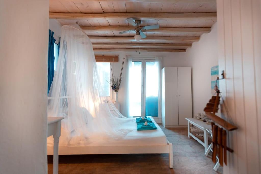 1 dormitorio con cama blanca y mosquitera en Seafarer's House. Ideal for 3+1 guests en Mykonos ciudad