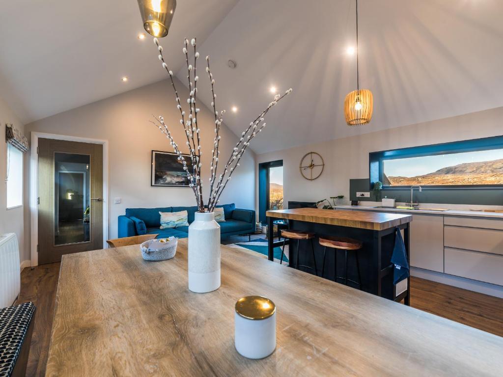 a kitchen and living room with a wooden table at Beinn Mhor View in Lochboisdale