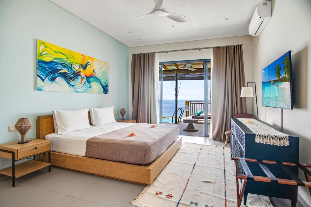 a bedroom with a bed and a view of the ocean at Paradise Chalets Yoga & Wellness in Takamaka