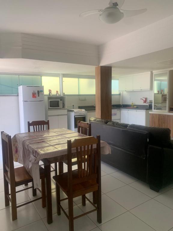 a kitchen with a table and chairs and a couch at Apto 2 Quartos Perfeito in Guarapari