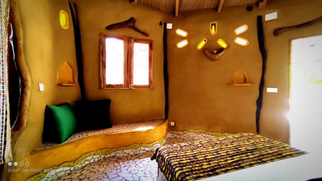 ein Schlafzimmer mit einem Bett in einem Zimmer mit einem Fenster in der Unterkunft NaturUbuntu in Kafountine