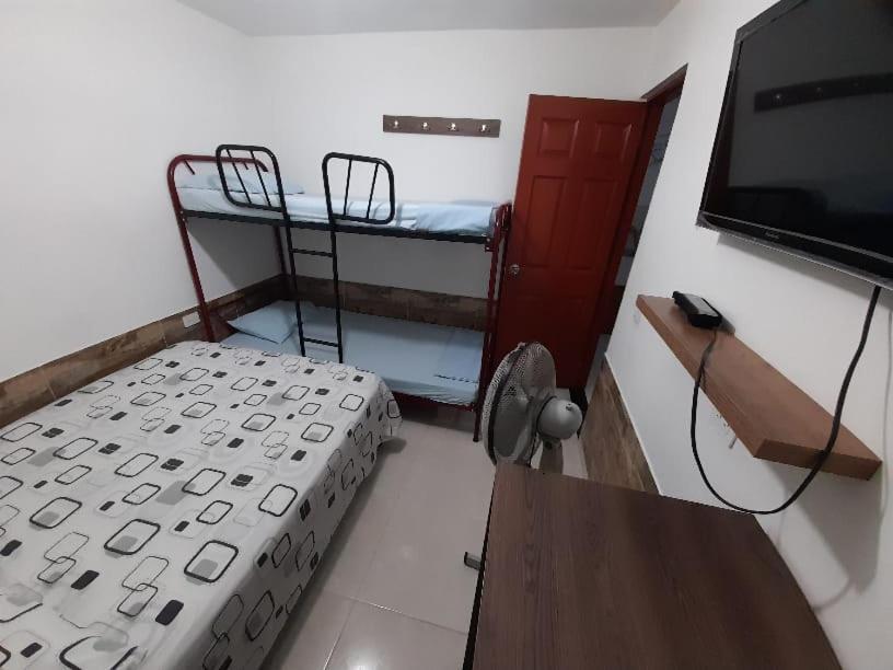 Pokój z 2 łóżkami piętrowymi i telewizorem z płaskim ekranem w obiekcie J79 Apartamentos Vacacionales w mieście Ibagué