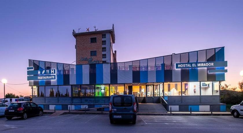 un autobús estacionado en un estacionamiento frente a un edificio en Hostal el Mirador de Barasoain, en Barásoain