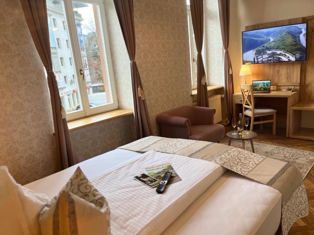 メルツィヒにあるHotel Stadtvilla Lauxのベッド、デスク、窓が備わるホテルルームです。