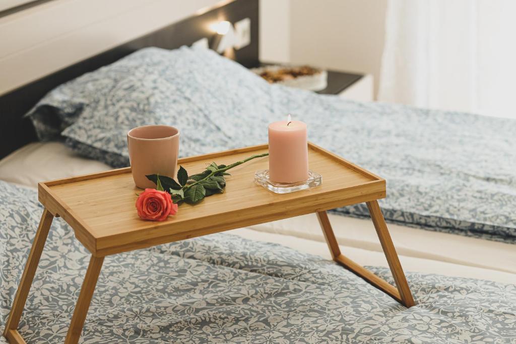 a wooden table with two candles and flowers on a bed at Carin Deluxe I in Vienna