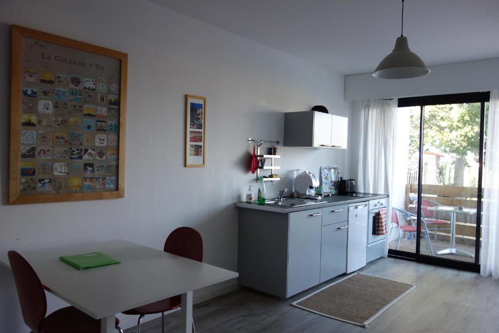 une cuisine avec une table et une table ainsi qu'une salle à manger dans l'établissement Nice colline charmant studio indépendant au rdc d'une maison, à Nice